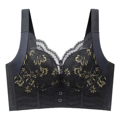 A black wire-free bra featuring floral lace overlays, wide straps, and a front hook closure.