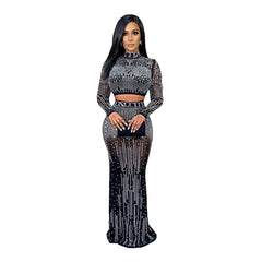 A woman wears a black two-piece long-sleeve dress featuring sheer mesh and rhinestone embellishments.