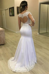 A white mermaid wedding dress with long lace sleeves and a sheer heart-shaped back.