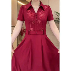 A short-sleeved, knee-length maroon dress with sequined floral appliques and a belted waist.