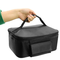 A hand holds a black, rectangular portable car food warmer bag with a top handle and zippered closure.