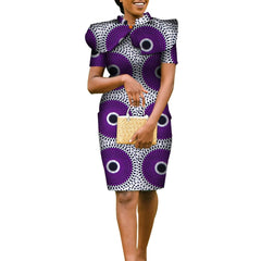 A woman wears a purple and white patterned pencil dress with a matching cape and gold clutch.