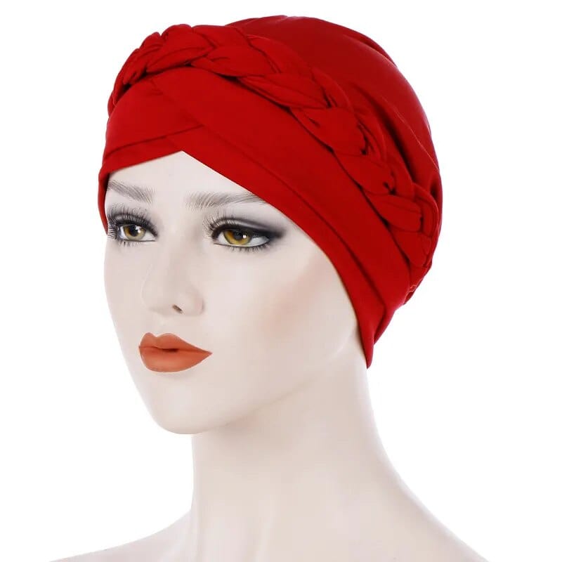 A mannequin wears a solid red cotton turban cap featuring a decorative braided headband detail.