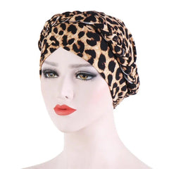 A mannequin wears a leopard print cotton turban with a braided headband detail.