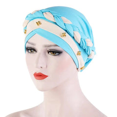 A light blue cotton turban cap featuring a beige braided headband accented with small pearls.