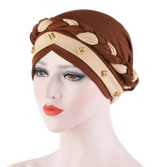 A brown and beige cotton turban cap featuring a braided design and small pearl embellishments.