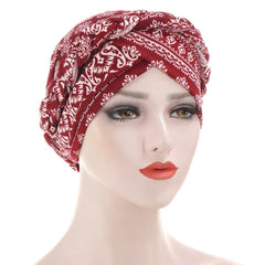 A mannequin wears a red and white patterned cotton turban head wrap.