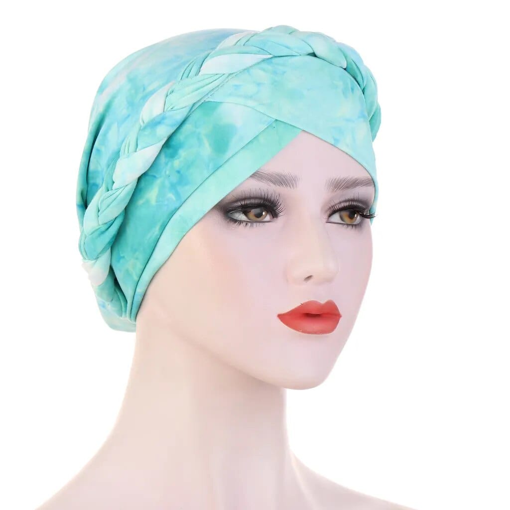 A mannequin wears a light blue and white tie-dye cotton turban with a braided headband detail.