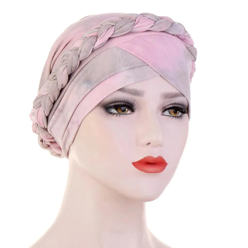 A mannequin wears a two-toned pink and grey cotton turban featuring a braided headband detail.