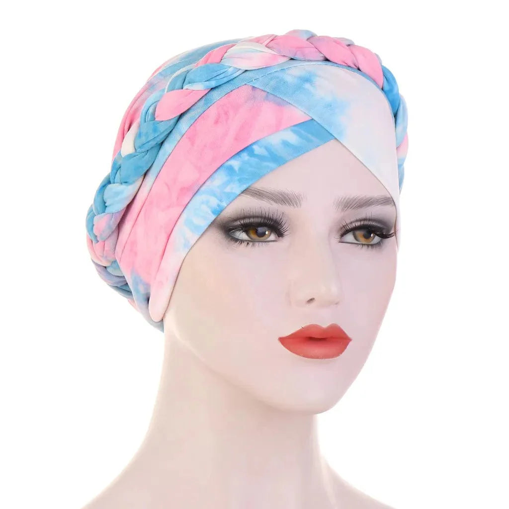 A mannequin wears a tie-dye cotton turban with a braided headband detail in pink and blue.