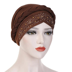 A brown cotton turban head scarf featuring a braided design and scattered pearl embellishments.