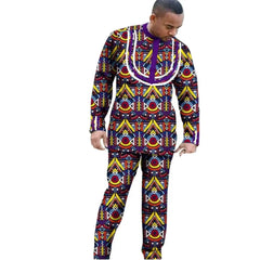 A man wears a long-sleeved, slim-fit African dashiki outfit with a colorful geometric pattern.