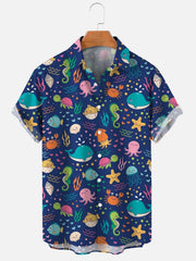 A short-sleeved button-down shirt with a blue background and a colorful sea life pattern.