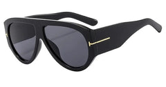 Oversized black pilot sunglasses with a thick frame and gold-tone temple accents.