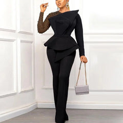A woman wears a black long-sleeved jumpsuit with a beaded transparent sleeve and peplum waist.