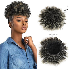 A woman wearing a curly afro puff drawstring ponytail hairpiece in black and blonde.