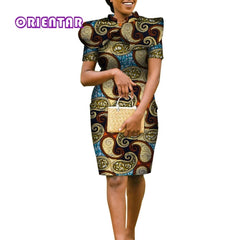 A woman wears a knee-length, short-sleeved pencil dress with a matching cape in a gold-dusted print.