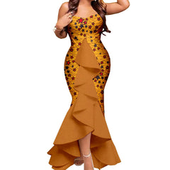 A woman wears a strapless, yellow, star-patterned mermaid dress with a large brown ruffled overlay.