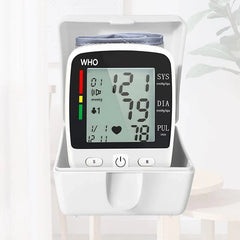 A white digital wrist blood pressure monitor with an LCD screen showing health readings.