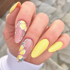 Long almond-shaped press-on nails featuring a mix of solid yellow and floral-painted designs.