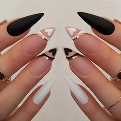 Long stiletto press-on nails featuring a mix of solid colors, heart designs, and gold accents.