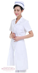 A woman wears a white short-sleeved nurse uniform gown and a matching nurse cap.