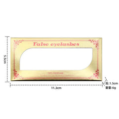 A rectangular gold eyelash packaging box with a clear window and floral corner accents.