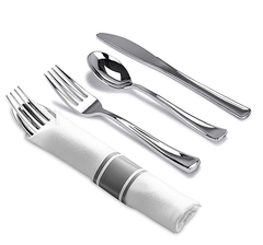 A set of silver-colored plastic cutlery including a fork, spoon, and knife wrapped in a napkin.