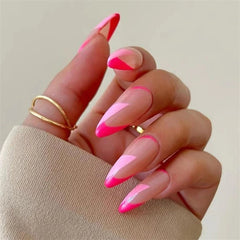 A hand displays almond-shaped press-on nails featuring a pink and light pink French tip design.