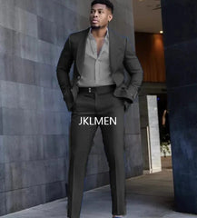 A man wears a slim-fit dark suit with a light grey button-down shirt.