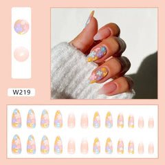 A set of twenty-four almond-shaped press-on nails featuring a sheer base with colorful floral art.
