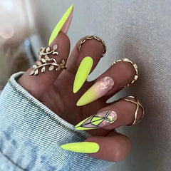 Long stiletto press-on nails in neon green with gradient, glitter, and geometric line designs.