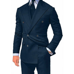 A man wears a dark blue double-breasted suit jacket with a white shirt and dark tie.