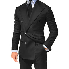 A man wears a black double-breasted suit jacket with a matching tie and white dress shirt.