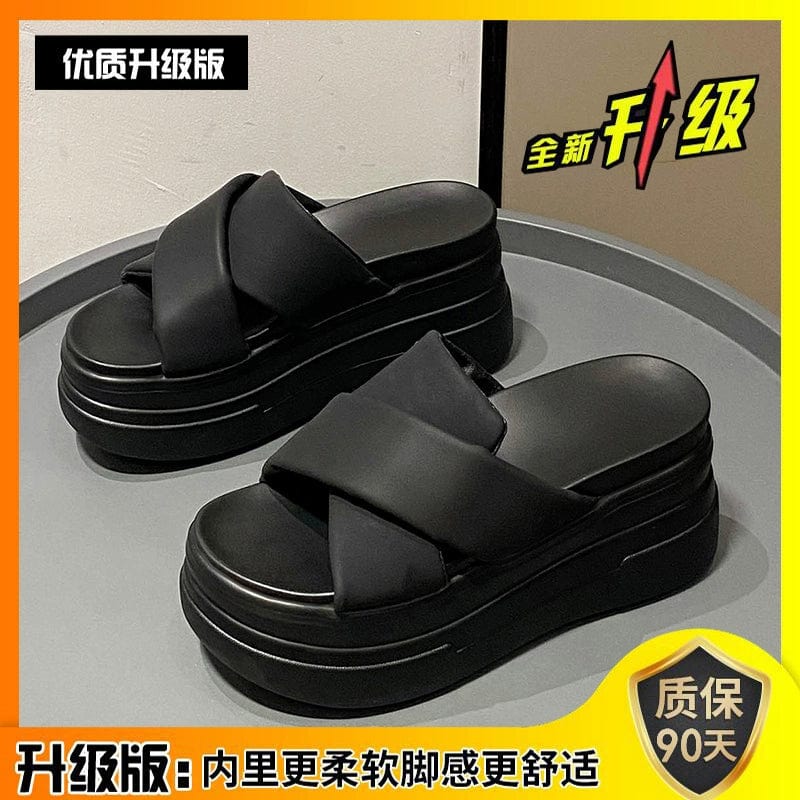 A pair of black platform sandals with thick muffin soles and wide crisscross straps.