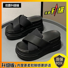 A pair of black platform sandals with thick muffin soles and wide crisscross straps.