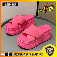 A pair of bright pink platform sandals with thick crisscross straps and a high muffin heel.