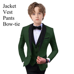 A young boy wears a dark green slim-fit tuxedo suit with a black shawl lapel, vest, and bow-tie.