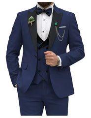 A slim fit navy blue three-piece tuxedo with a black peak lapel, bow tie, and vest.