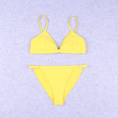 A bright yellow triangle bikini set with thin straps and side ring details on the bottoms.