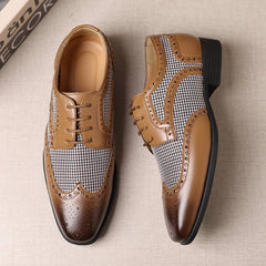 A pair of brown and plaid lace-up men's business shoes with a square toe and rubber sole.