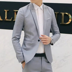 A man wears a slim-fit light grey formal blazer with a single button and notched lapels.