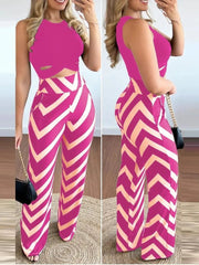 A woman wears a sleeveless hot pink crop top and matching high-waisted chevron print trousers.