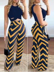 A woman wears a navy sleeveless crop top paired with high-waisted trousers featuring a yellow chevron print.