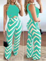 A woman wears a sleeveless teal cropped top and matching high-waisted trousers with a chevron print.