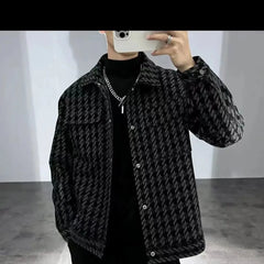 A man wears a black and white houndstooth patterned jacket with a square collar.