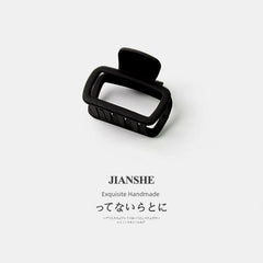 A matte black square hair claw clip shown against a plain white background.