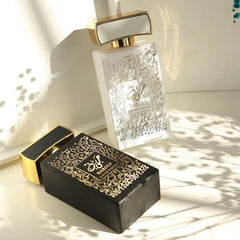 Two rectangular perfume bottles with gold caps and intricate Arabic calligraphy designs.