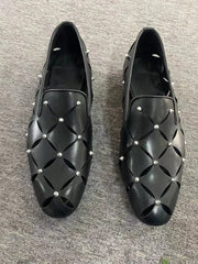 Black leather loafers featuring a hollow-out diamond pattern and silver stud embellishments.