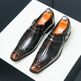 A pair of brown pointed-toe dress shoes with decorative studs and side buckle straps.